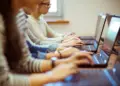 AI in Education Pros and Cons: Evaluating the Impact of Technology on Learning Students on computers learning possibly using AI