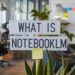 Office space with a sign reading "What is NotebookLM" above plants and desks, with sticky notes on a distant whiteboard.
